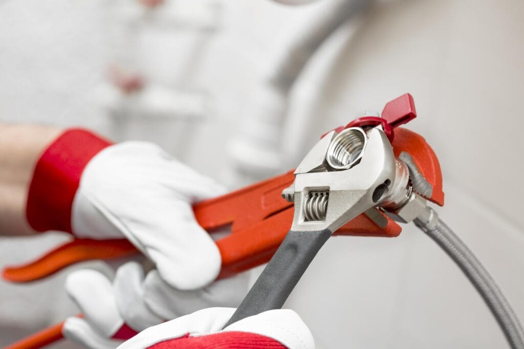 Plumber holding pipe wrenches for an emergency repair in Douglasville