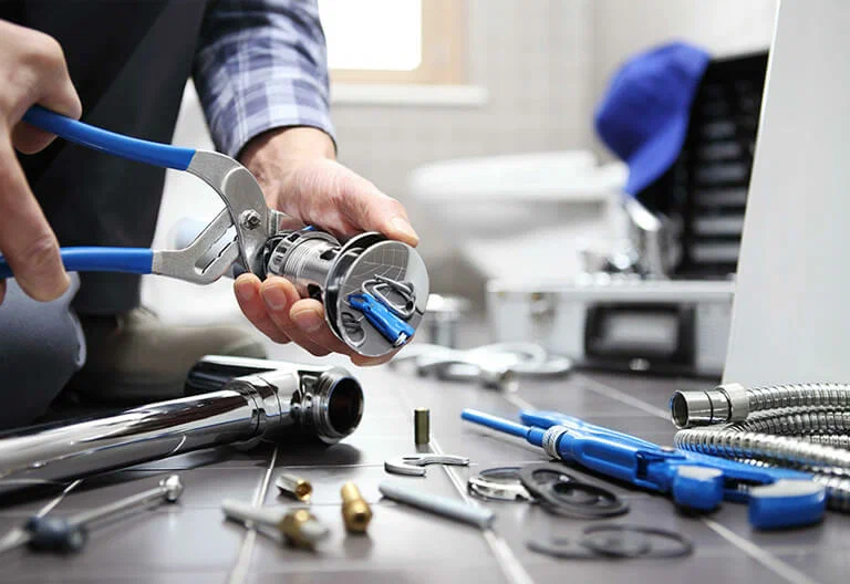 Technician repairing a plumbing fixture with professional tools in Douglasville