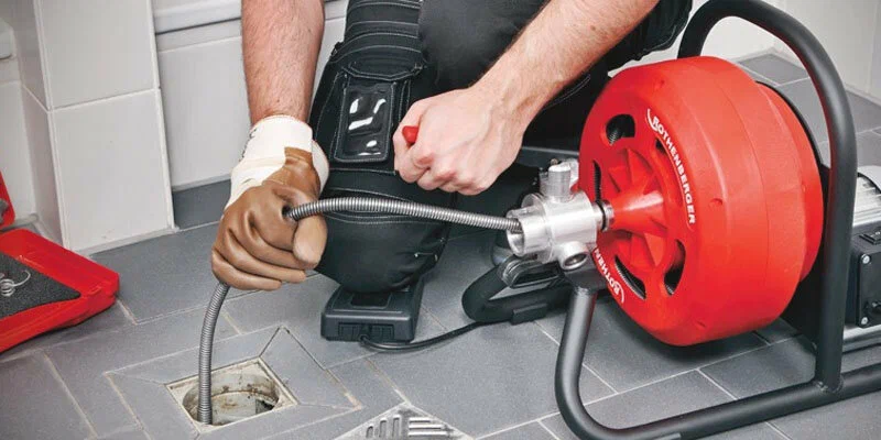 Plumber using a drain-cleaning machine in Douglasville