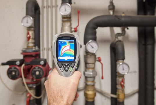 Plumber using a thermal imaging camera to inspect pipes in Douglasville